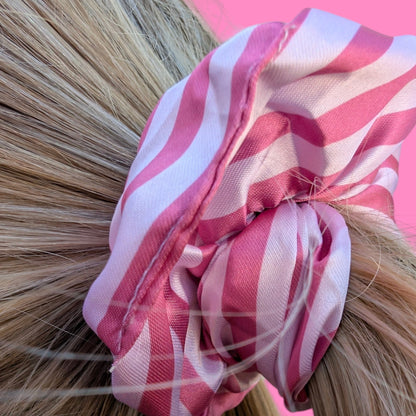Chouchou Limone&Sole en satin rayé rose et blanc noué dans des cheveux blonds pour un style élégant et doux